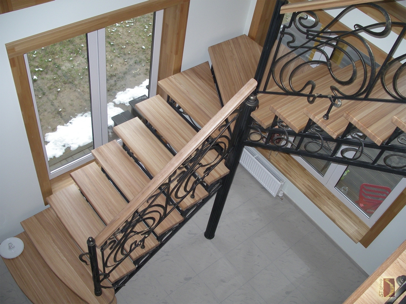 Металлическая, поворотная лестница без площадок с коваными перилами и деревянными ступеньками